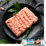 Ground chicken on a black plate with herbs, branded packaging in the corner.