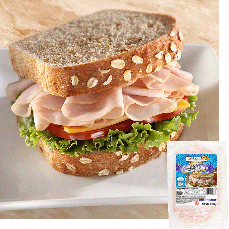 a turkey sandwich with oats baked into the top of the bread. The sandwich is piled high with Midamar halal turkey which is resting on a slice of cheese, tomatoes, and lettuce. In the bottom corner is an image of the product package