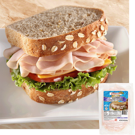 a turkey sandwich with oats baked into the top of the bread. The sandwich is piled high with Midamar halal turkey which is resting on a slice of cheese, tomatoes, and lettuce. In the bottom corner is an image of the product package