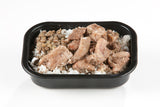 A packaged meal containing Halal chicken thigh pieces, onions, and rice served in a black tray.